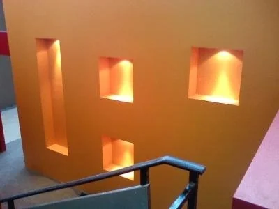 Τοίχος κλιμακοστασίου με τρεις ορθογώνιες εσοχές και θερμό κρυφό φωτισμό.