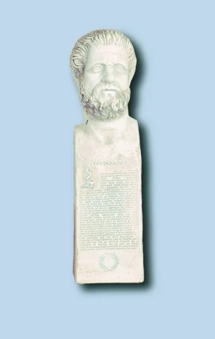 Επιμήκης προτομή γενειοφόρου ανδρικής μορφής πάνω σε στενή βάση.